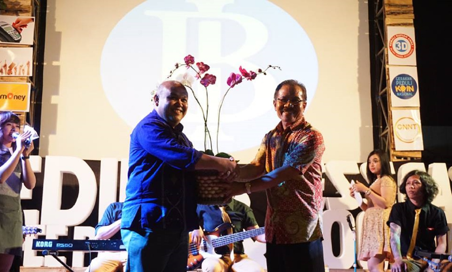 Direktur Kampoeng Anggrek Dr. Zaenudin (sebelah kanan) menyerahkan anggrek kepada Kepala Bank Indonesia Perwakilan Kediri, Djoko Raharto. (foto : fb ngopingopinet)